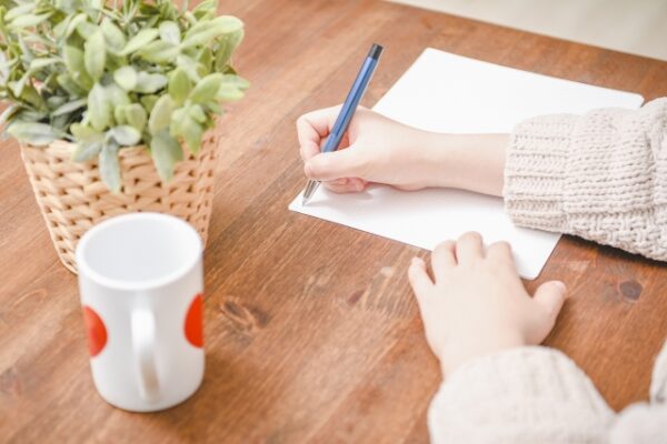 書類に記入している女性の手元